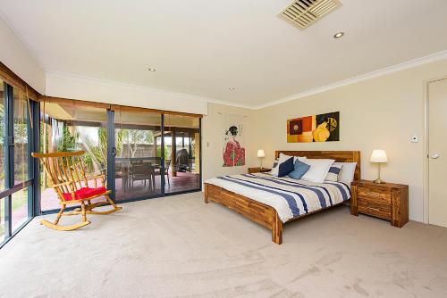 une chambre avec un lit et une chaise dedans dans l'établissement Sky Blue Retreat Serene Family Getaway, à North Boyanup