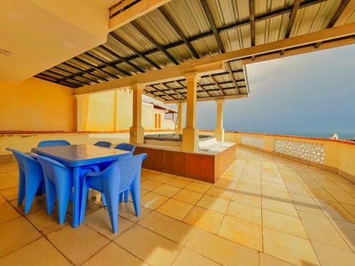 a dining room with a blue table and chairs at Shanzu Oceanfront Apartments and Suites in Mombasa