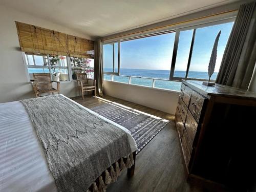 a bedroom with a bed and a view of the ocean at Beach front villa , All Mare 2 in Uluwatu