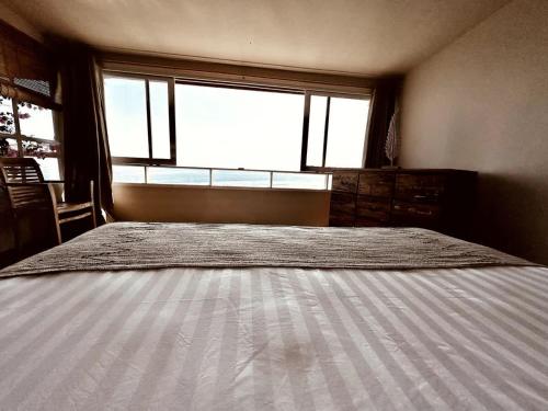 a bedroom with a large bed with a window at Beach front villa , All Mare 2 in Uluwatu
