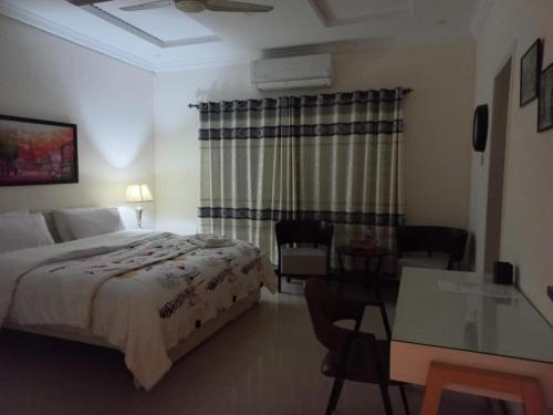 a hotel room with a bed and a table and a dining room at Four Season Guest House in Islamabad