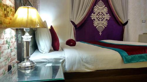 a bedroom with a bed and a table with a lamp at Four Season Guest House in Islamabad