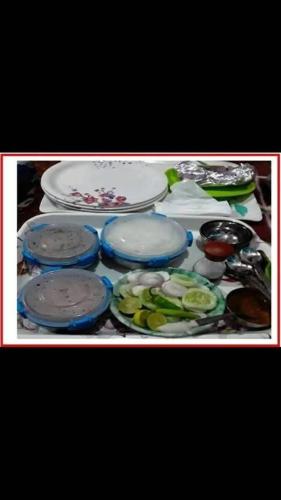 a table with plates and bowls on top of it at Hotel Gokul International Bhadarwah in Doda
