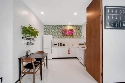 a kitchen with white cabinets and a table and chairs at Las Olas Hammocks Unit 2 By Pmi in Fort Lauderdale