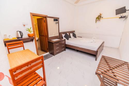 a bedroom with a bed and a desk and a mirror at Wood Land Airport residences in Seeduwa