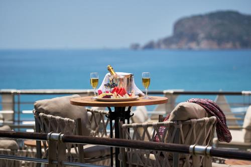 a table with two glasses of wine on a balcony at Hotel Grand Kaptan - Ultra All Inclusive in Alanya
