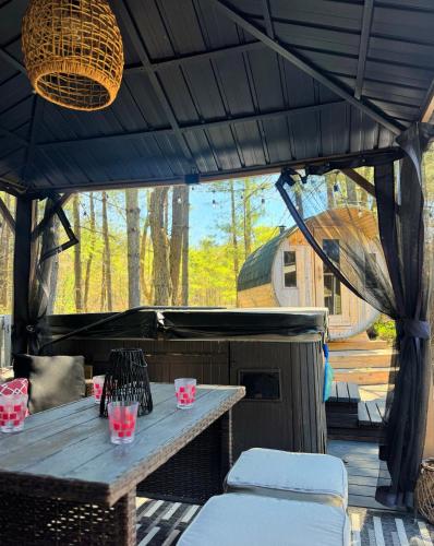 a patio with a wooden table and some chairs at Stunning 3br Waterfront Lake Cottage Hottub&sauna in Gravenhurst