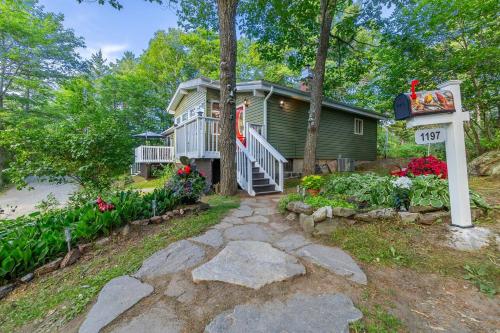 a house with a garden and a pathway leading to it at Stunning 3br Waterfront Lake Cottage Hottub&sauna in Gravenhurst