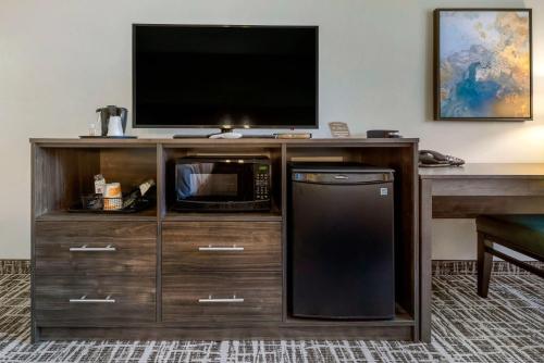 a entertainment center with a television and a microwave at Quality Inn St Cloud West in Saint Cloud
