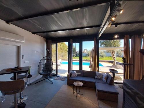a living room with a couch and a swimming pool at Hacienda MATEA an oasis of romance near the beaches, surrounded by olive trees, pool, jacuzzi and playground, Pula - Istria in Pula