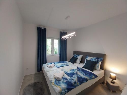 a bedroom with a bed with blue and white sheets at Hacienda MATEA an oasis of romance near the beaches, surrounded by olive trees, pool, jacuzzi and playground, Pula - Istria in Pula