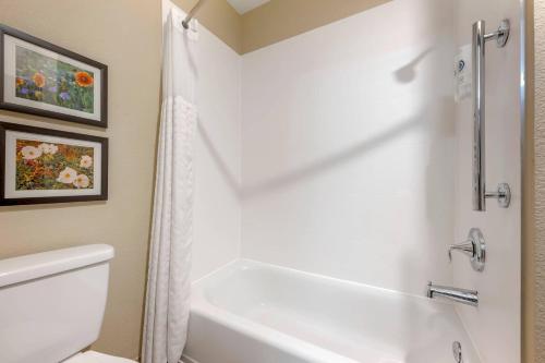 a bathroom with a white tub and a toilet at Comfort Inn I-20 Midland Stanton in Stanton