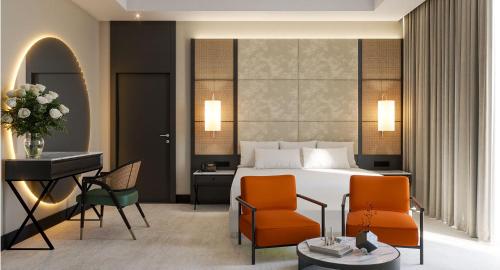 a hotel room with a bed and a desk and chairs at Anantara Downtown Dubai in Dubai