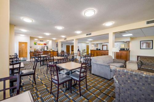 a restaurant with tables and chairs and a couch at Quality Inn Fredericksburg-Central Park Area in Fredericksburg