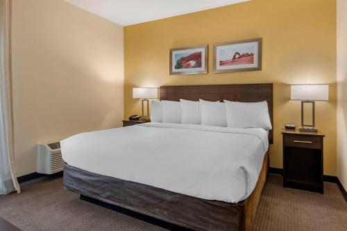 a large bed in a hotel room with two lamps at MainStay Suites Moab near Arches National Park in Moab