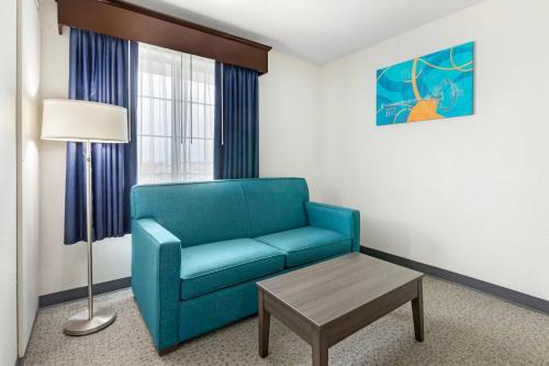 a living room with a blue couch and a table at MainStay Suites Madison Airport in Madison