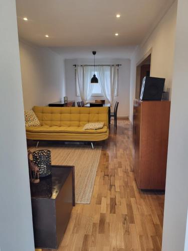 a living room with a yellow couch and a table at Casa da travessa familial e com terraço in Porto
