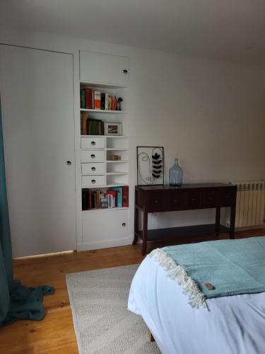 a bedroom with a desk and a book shelf with books at Casa da travessa familial e com terraço in Porto