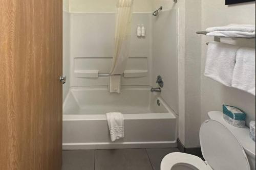 a bathroom with a white tub and a toilet at Country Inn & Suites by Radisson, Monterey Beachfront-Marina, CA in Marina