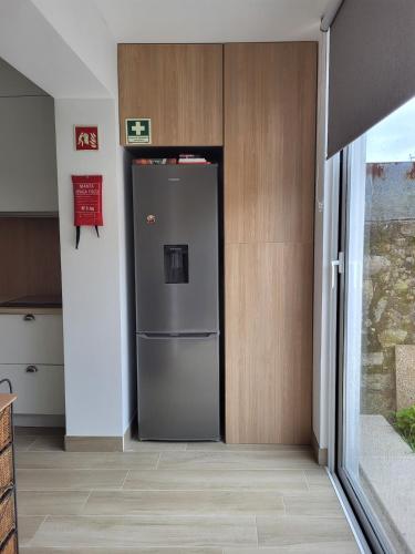 a stainless steel refrigerator in a kitchen next to a door at Casa da travessa familial e com terraço in Porto