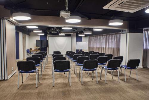 a room with a bunch of chairs and a screen at Faranda Collection Cali, a member of Radisson Individuals in Cali