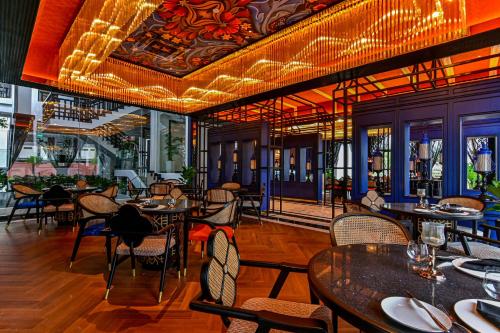 a dining room with tables and chairs in a restaurant at Bertam Wellness Spa & Villas - A Member of Small Luxury Hotels of the World in Kepala Batas
