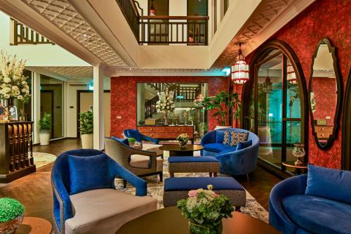 a hotel lobby with blue chairs and tables at Bertam Wellness Spa & Villas - A Member of Small Luxury Hotels of the World in Kepala Batas