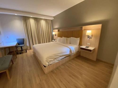 a hotel room with a large bed and a desk at Radisson Colon 2,000 Hotel & Casino in Colón