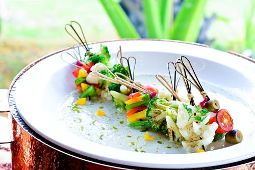 a plate of food with skewers on top of it at Bertam Wellness Spa & Villas - A Member of Small Luxury Hotels of the World in Kepala Batas