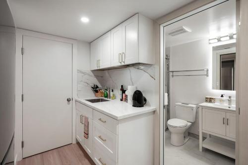 ein weißes Badezimmer mit Toilette und Waschbecken in der Unterkunft Cozy 1bedroom Unit near City College of SF & Bart Station in San Francisco