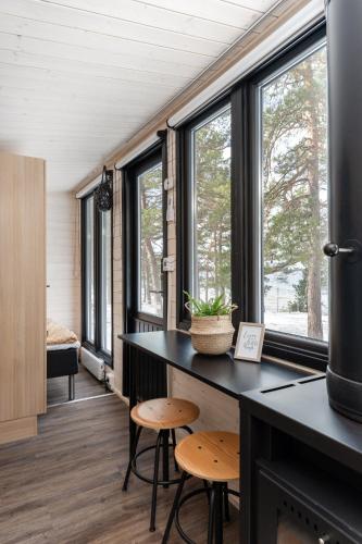 a room with windows and a counter with stools at Beach house with sauna in Hanko