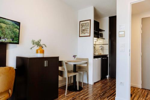 a small kitchen and a table in a room at Clarion Aparthotel Toulouse Le Parc de l'Escale in Toulouse
