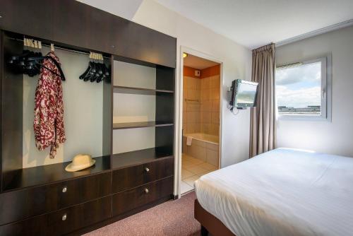 a bedroom with a bed and a bathroom with a shower at Clarion Aparthotel Toulouse Le Parc de l'Escale in Toulouse