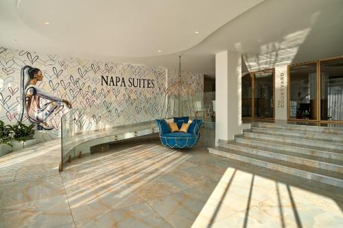 a lobby of a building with a blue chair at Hotel Napa Suites (Adults Only) in Ayia Napa