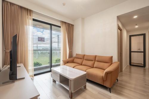 a living room with a couch and a tv at Studio-GH5 - Vinhomes Grand Park - Thu Duc City in Long Bình