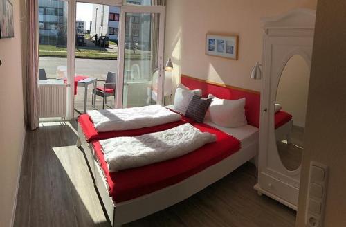 a bedroom with a bed with a red and white headboard at Am Rundsteg 5 in Burgtiefe auf Fehmarn 