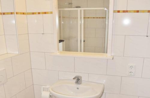 a white bathroom with a sink and a mirror at Am Rundsteg 9 in Burgtiefe auf Fehmarn 