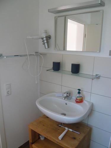 a bathroom with a white sink and a mirror at Aloha 2 in Neue Tiefe Fehmarn
