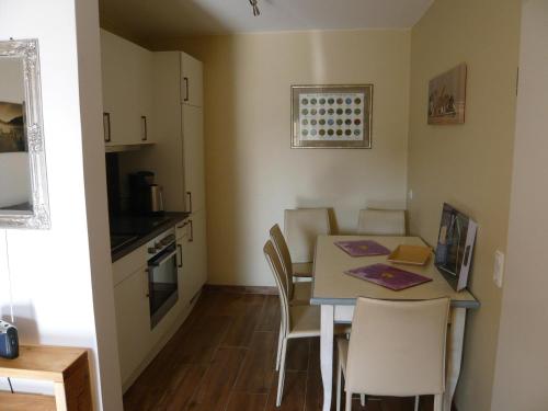 une petite cuisine et salle à manger avec une table et des chaises dans l'établissement Aloha 1, à Neue Tiefe Fehmarn