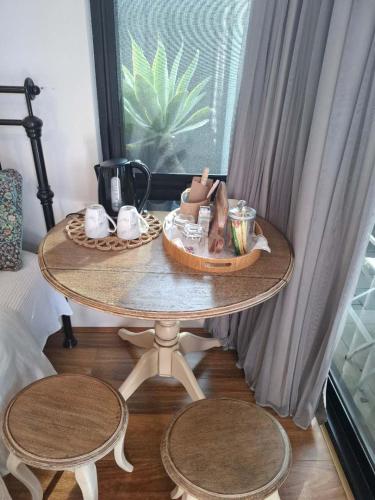 Una mesa con dos sillas y una mesa con objetos sobre ella. en Guest Suite, Private Entrance, Bathroom, Garden, No Overlap with Host, en Perth