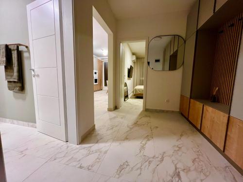 a hallway with marble flooring and a mirror at Olive&Air Haven in Cluj-Napoca