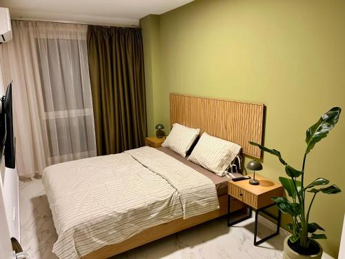 a bedroom with a bed and a potted plant at Olive&Air Haven in Cluj-Napoca