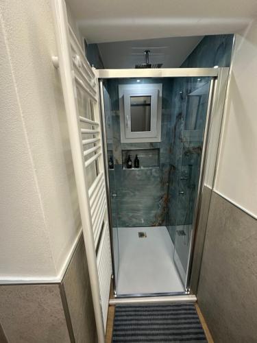 cabina doccia con porta in vetro in bagno di Sole Apartment Livorno a Livorno