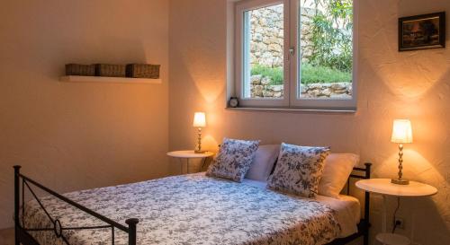 Un dormitorio con una cama con dos lámparas y una ventana. en Waterfront Apartment, en Kućište