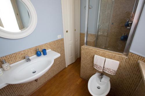 een badkamer met een wastafel, een toilet en een spiegel bij Antica Maison in Ascoli Piceno