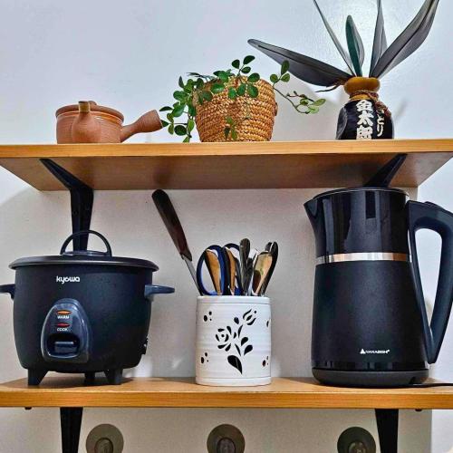 a shelf with a coffee maker and utensils at Cozy Condo AC Wi-Fi Netflix Ligao Natl Rd Rm 303 in Ligao