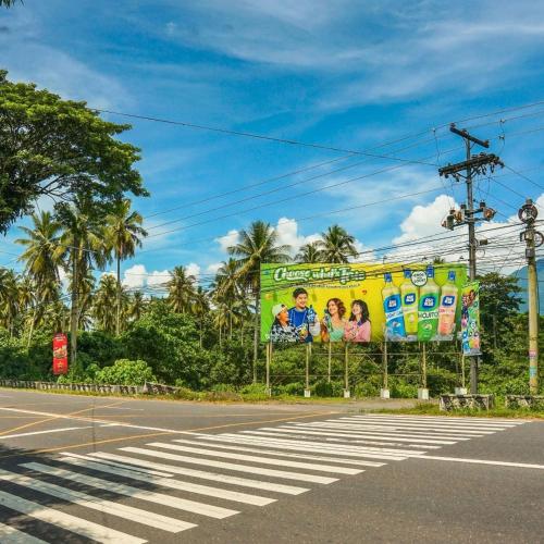 a billboard on the side of a street at Cozy Condo AC Wi-Fi Netflix Ligao Natl Rd Rm 303 in Ligao