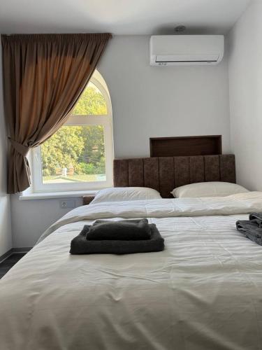 a large white bed with a pillow on it with a window at APETIKO APARTMENTs in Kyiv