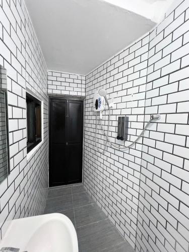 a bathroom with a toilet and a black door at Quee Hotel in George Town