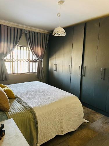 Knovi Guesthouse في بولاوايو: غرفة نوم بها سرير كبير ونافذة
